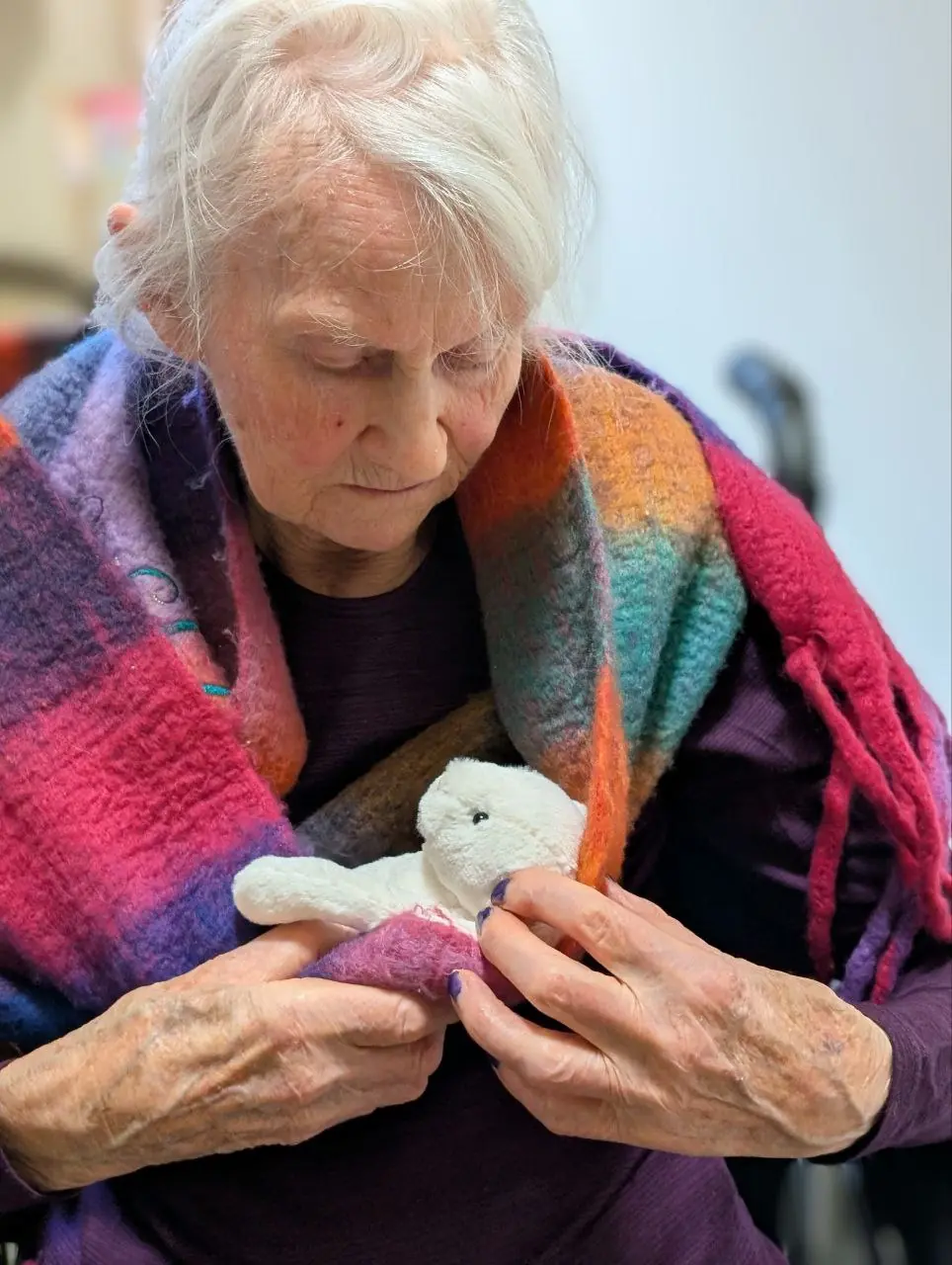 Senior smiling while holding a toy